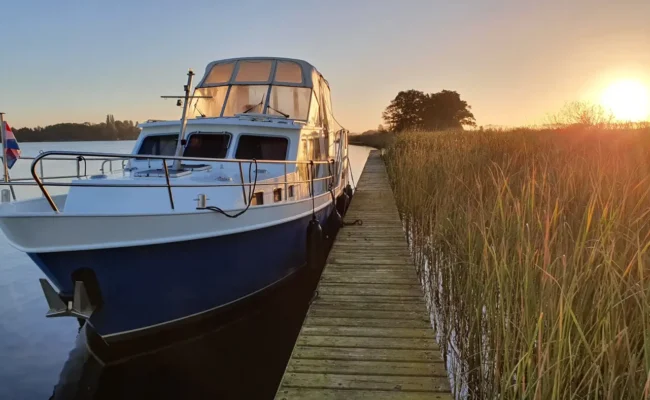 Motorjacht aan de steiger bij zonsondergang